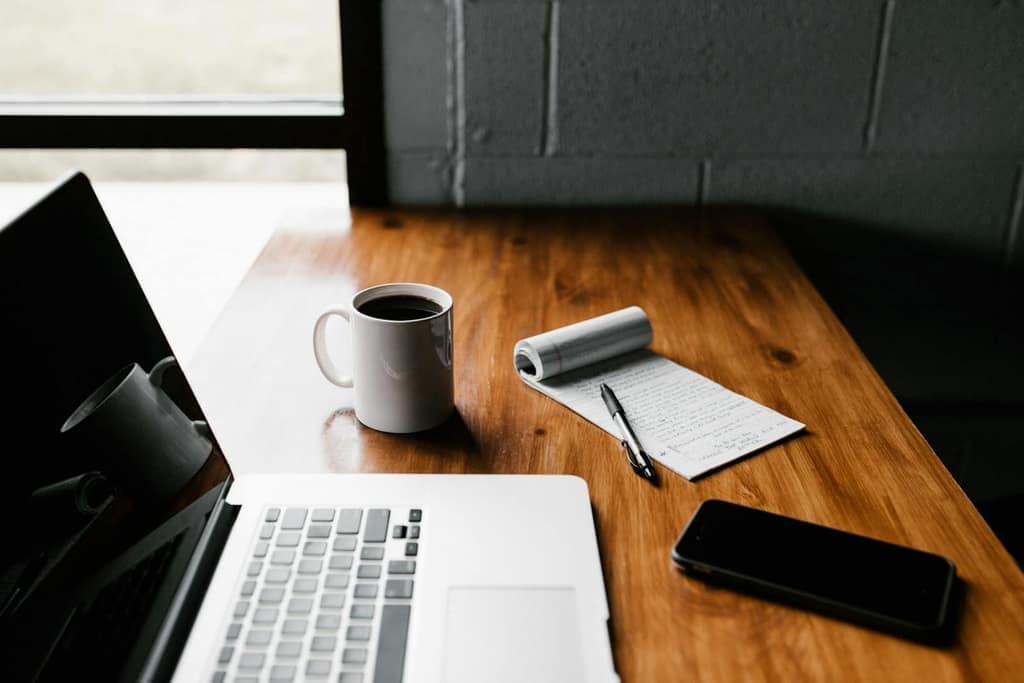 Notebook and laptop on a wooden desk